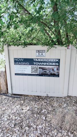 Timbercreek Townhomes Now Leasing banner sign on a fence
